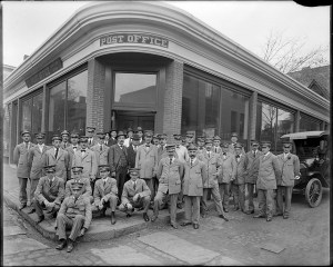 A group of proud USPS employees outside of the Post Office in Boston, MA. Photo via FLICKR/Boston Public Library